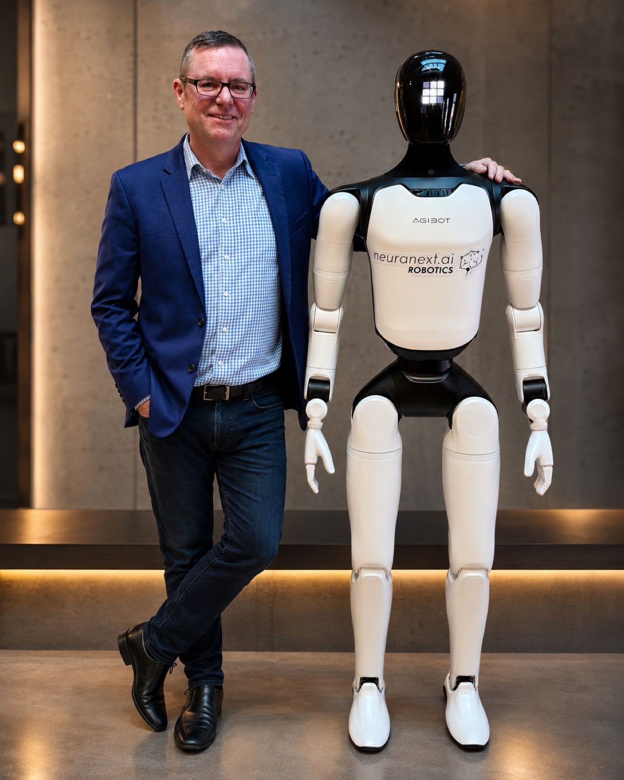 Adrian Tyson standing beside a Neuranext Agibot humanoid robot