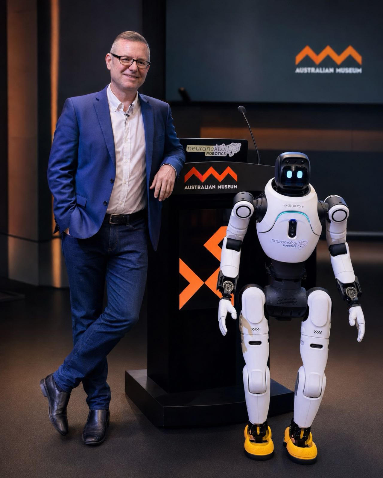 Adrian Tyson beside an AGIBOT humanoid robot at the Australian Museum