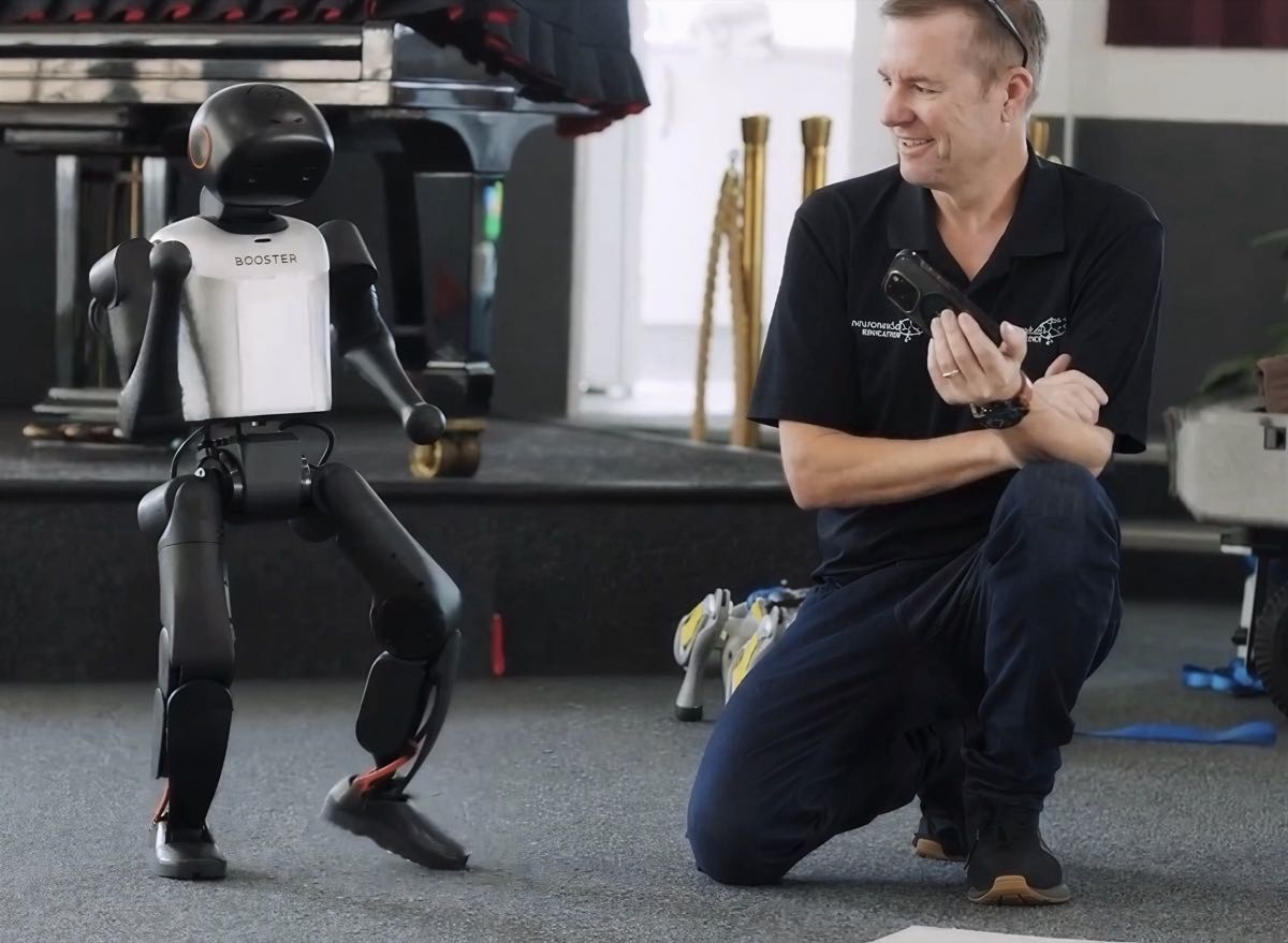 Adrian Tyson operating a Booster humanoid robot