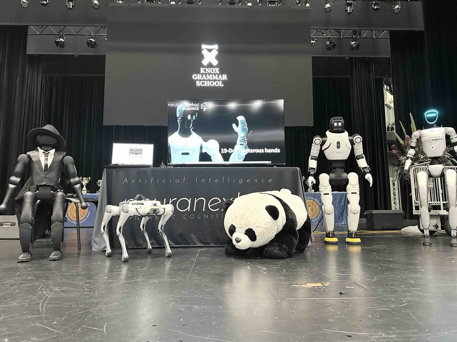 Humanoid and quadruped robots displayed on stage at Knox Grammar School